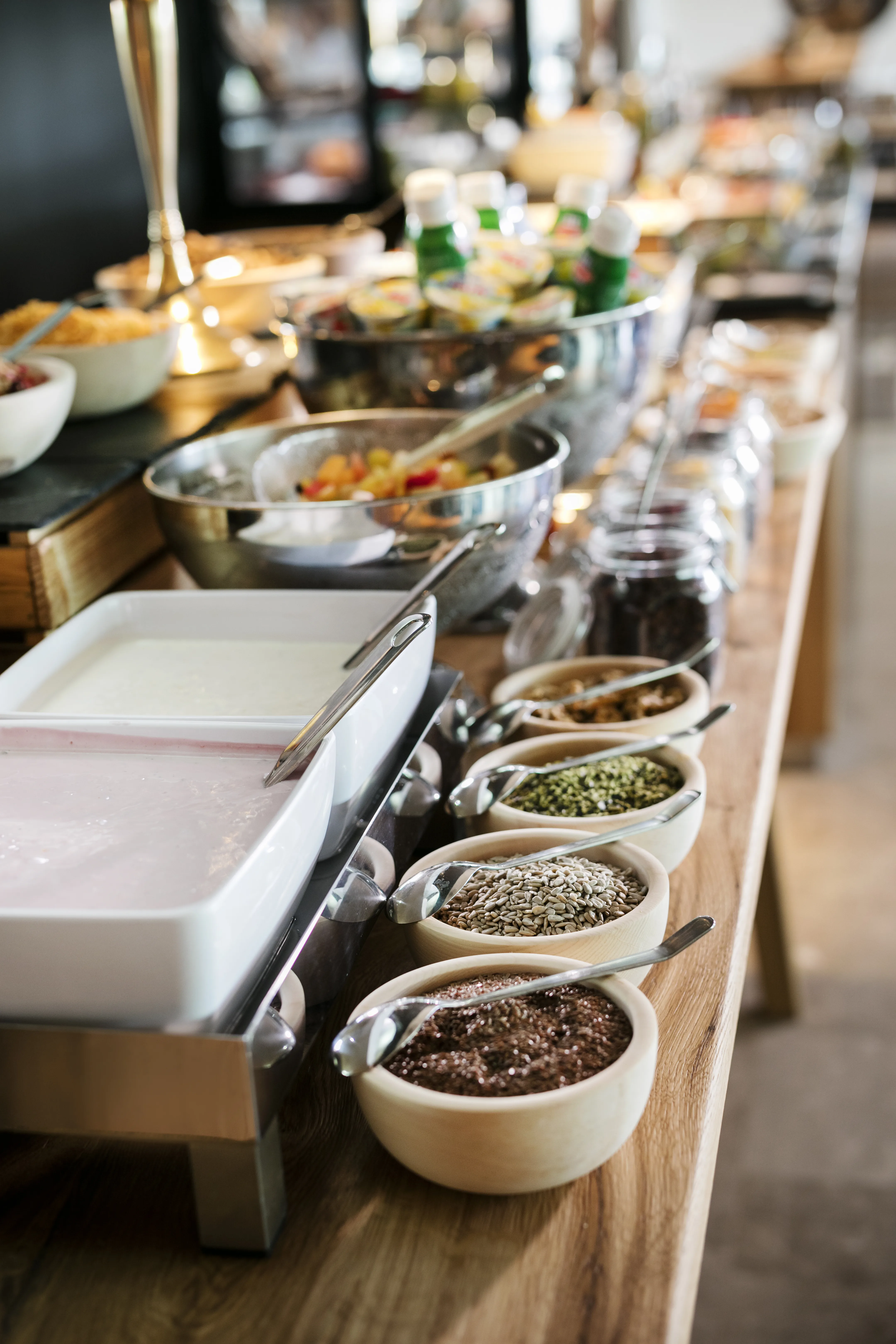 Ein Buffet mit Schalen voller Zutaten wie Joghurt, Müsli und Gewürzen.