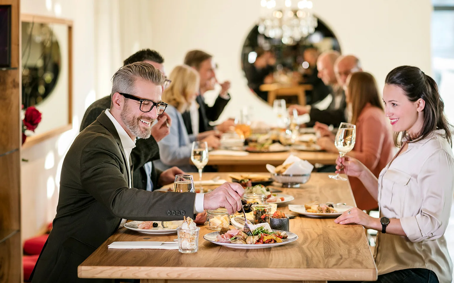 Eine Gruppe von Menschen genießt ein gemeinsames Essen in einem stilvollen Restaurant.