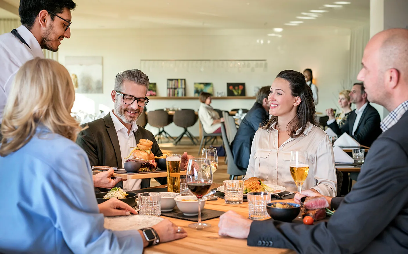 Eine Gruppe von Gästen genießt ein elegantes Dinner in einem Restaurant.