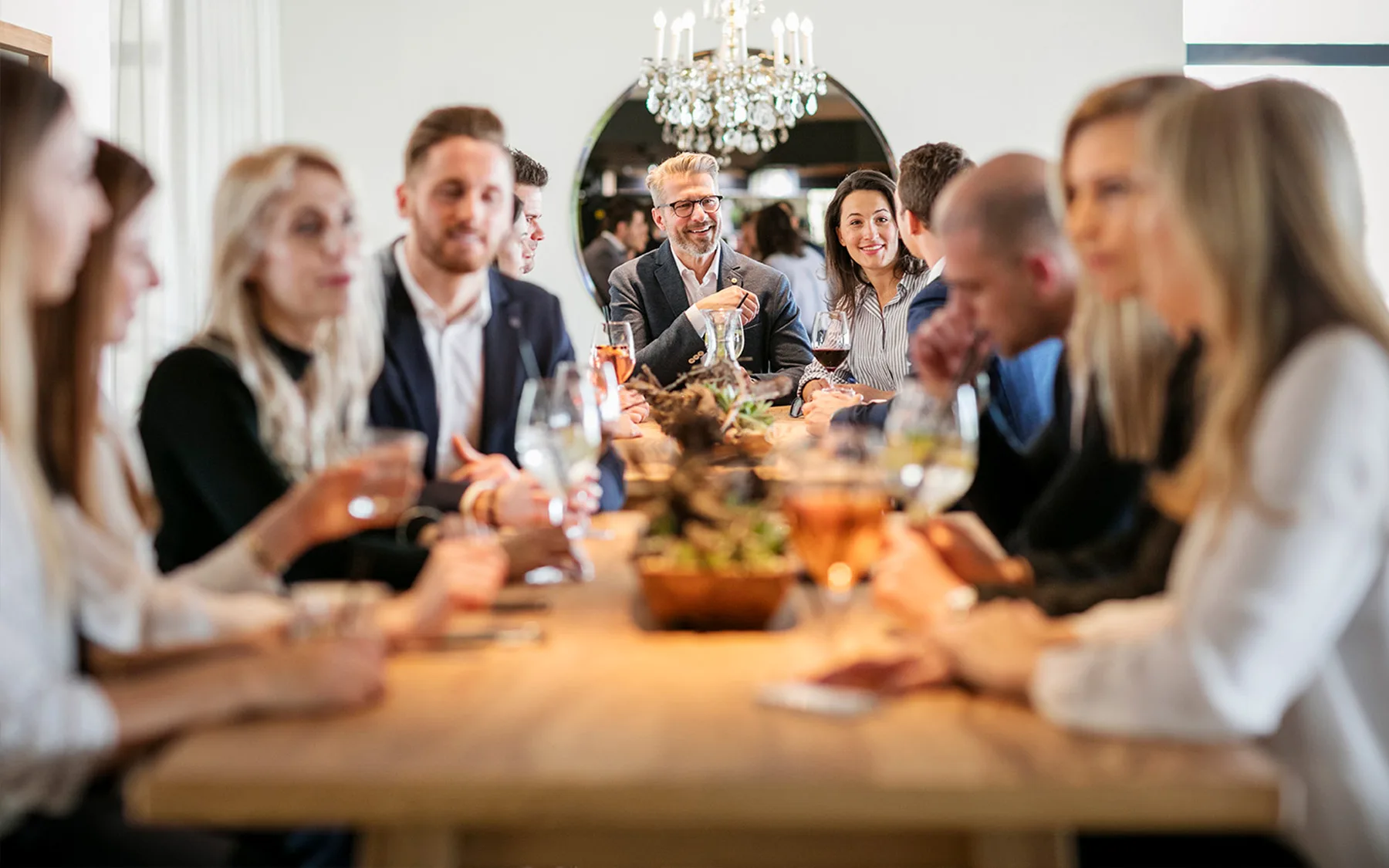 Eine Gruppe von Menschen sitzt an einem Tisch und genießt Getränke.
