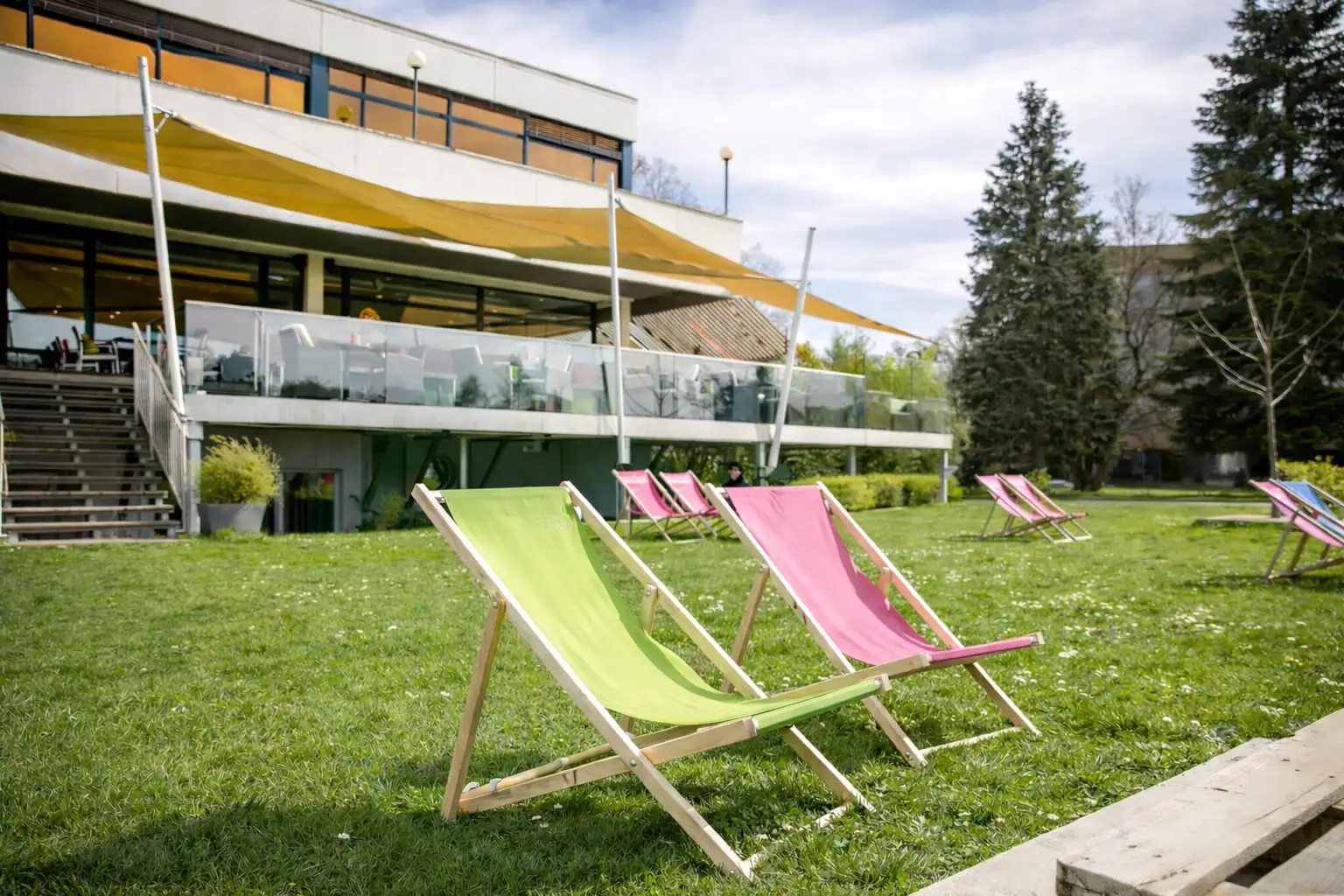 Colorful deck chairs on the lawn in front of the restaurant in summer